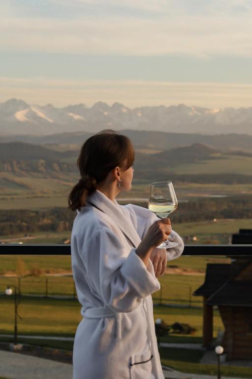 a woman holding a glass of white wine at Gorczański Lux Chalet in Szlembark