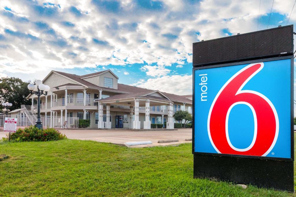 un cartel de la casa delante de una casa en Motel 6-Waxahachie, TX, en Waxahachie