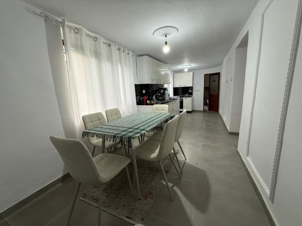 a dining room table and chairs in a kitchen at Canyon River House in Çorovodë