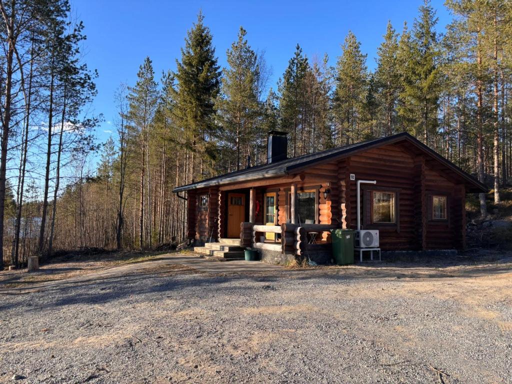 a log cabin in the woods with a gravel driveway at Kalliorinteen Mökit Havupirtti in Töysä
