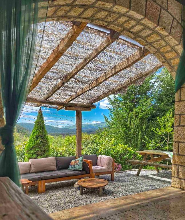 a patio with a couch and a table with a view at Chalet St John in Slatino