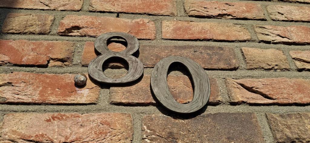 a metal number on the side of a brick wall at Haus Biber - altersgerechtes Ferienhaus am Niederrhein - in Sonsbeck