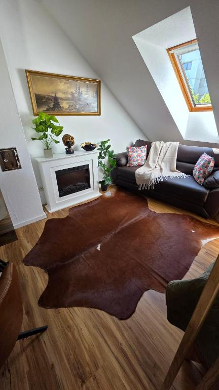 a living room with a couch and a fireplace at Golden Leaf Apartment with Parking in Burghausen