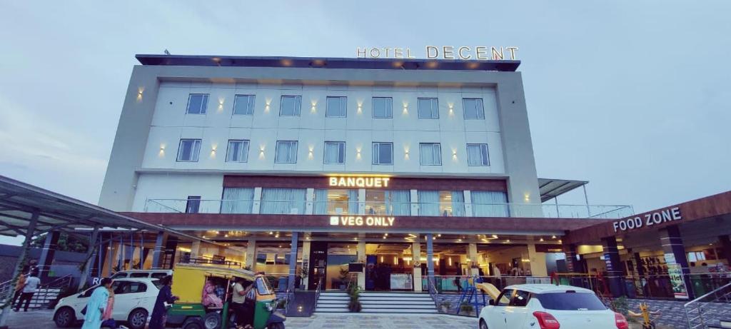 a building with cars parked in front of it at Hotel Decent in Bhāndu