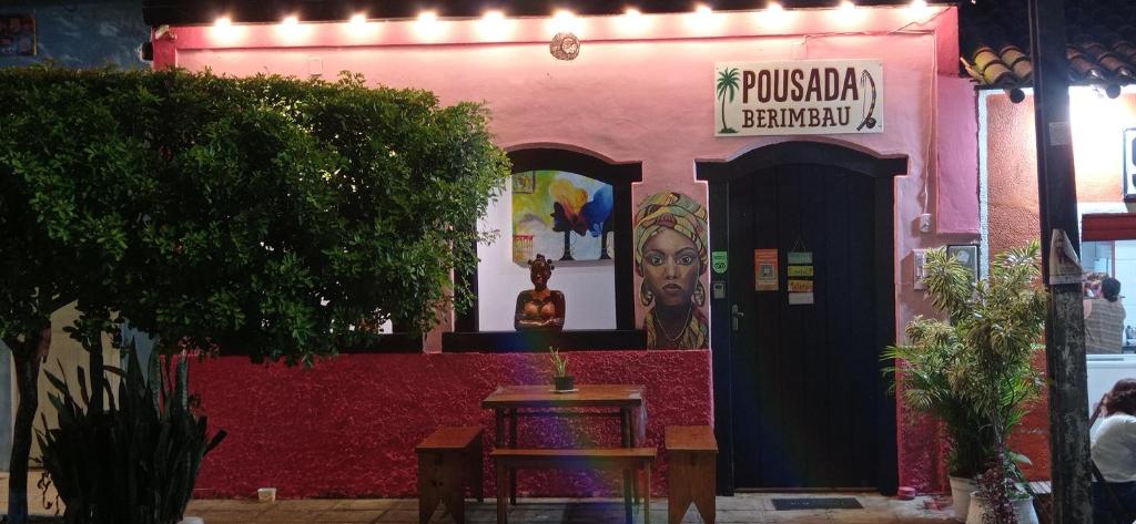 a pink building with a sign on it at Pousada Berimbau in Arraial d'Ajuda