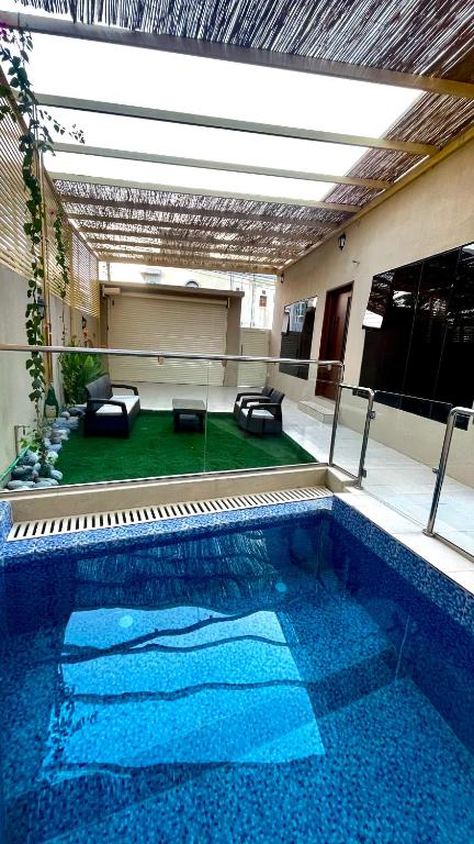 a swimming pool with couches and a couch in a building at Thuraya chalet in Nizwa