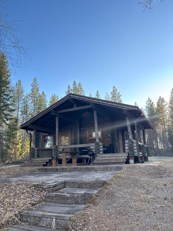 a log cabin with a picnic table in the woods at Kalliorinteen Mökit Suvipirtti in Töysä