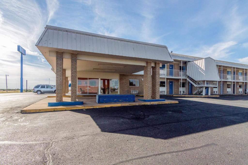 a building with a car parked in a parking lot at Motel 6-Clinton, OK in Clinton