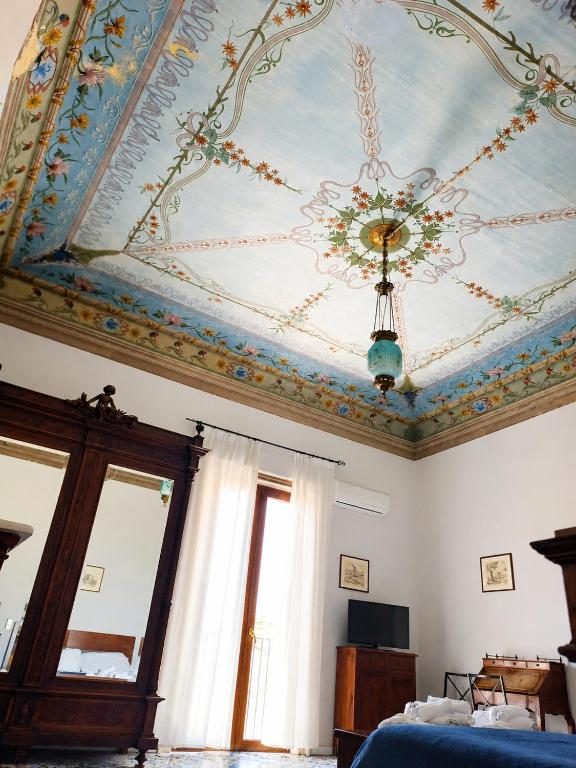a room with a painted ceiling and a chandelier at Alloggio della Posta Vecchia in Agrigento