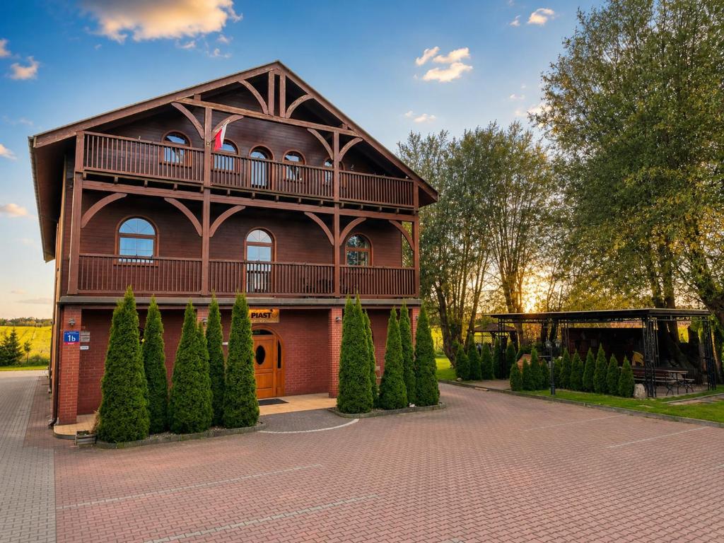 a building with a balcony on the side of it at Gościniec Piast Pokoje i Camper Park in Brzeźno
