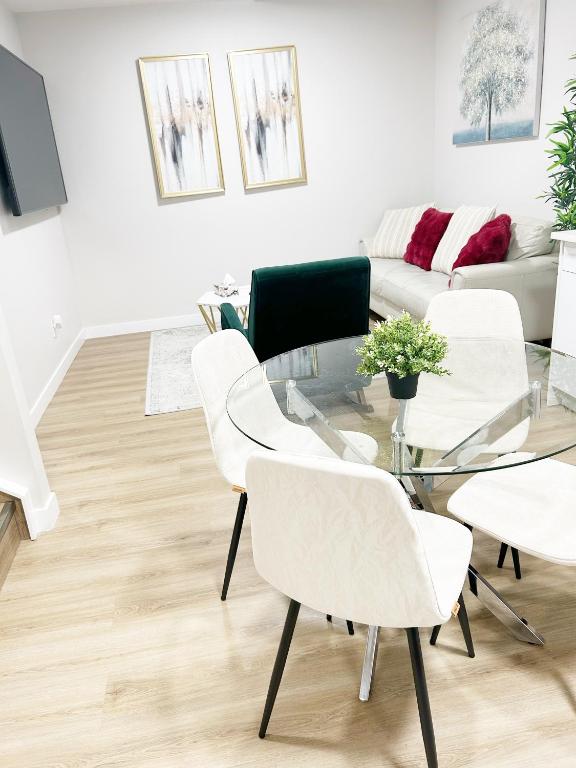a living room with a glass table and white chairs at DeHaven in Edmonton