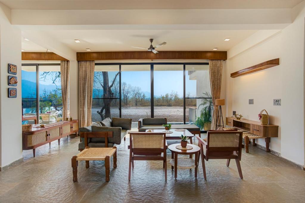 a living room with a couch and a table and chairs at The Mountain house 4 BHK VIlla With Pool in Rishīkesh