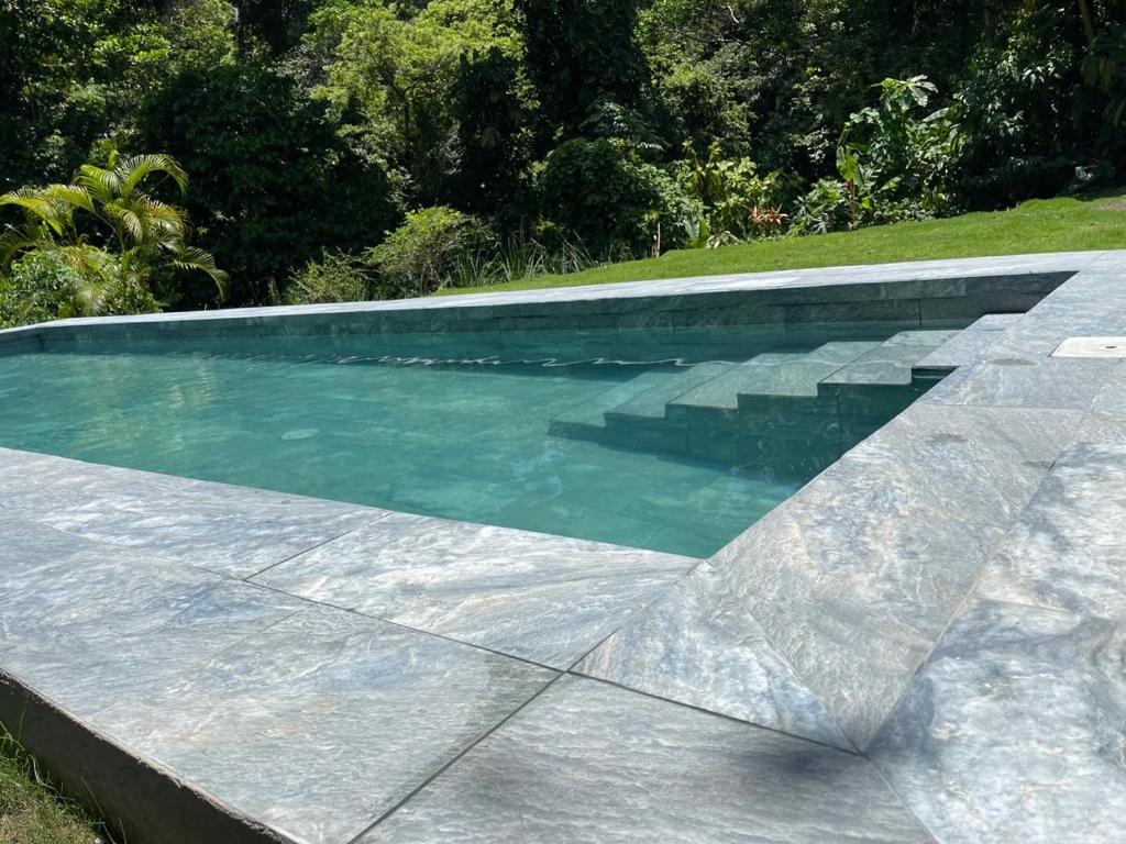 a swimming pool with blue water in a yard at Hotel Boutique D Angelo in Manzanillo