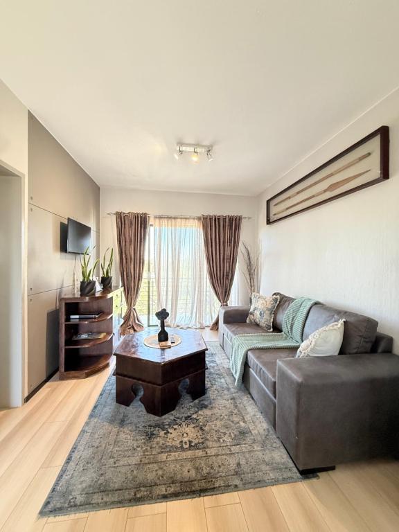 a living room with a couch and a coffee table at Broadacres apartment-work or play -swimming pool in Sandton