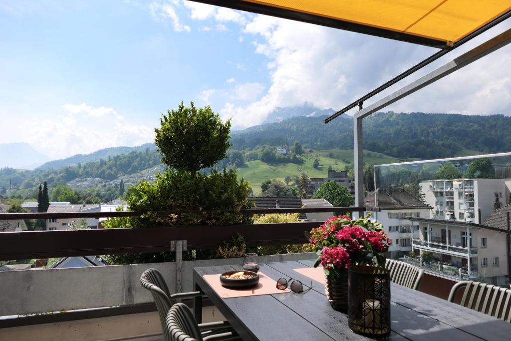 ein Tisch auf einem Balkon mit Blick auf die Berge in der Unterkunft View Pilatus-Luxus-Maisonette mit Pilatusblick - 6 Personen - PP in Luzern
