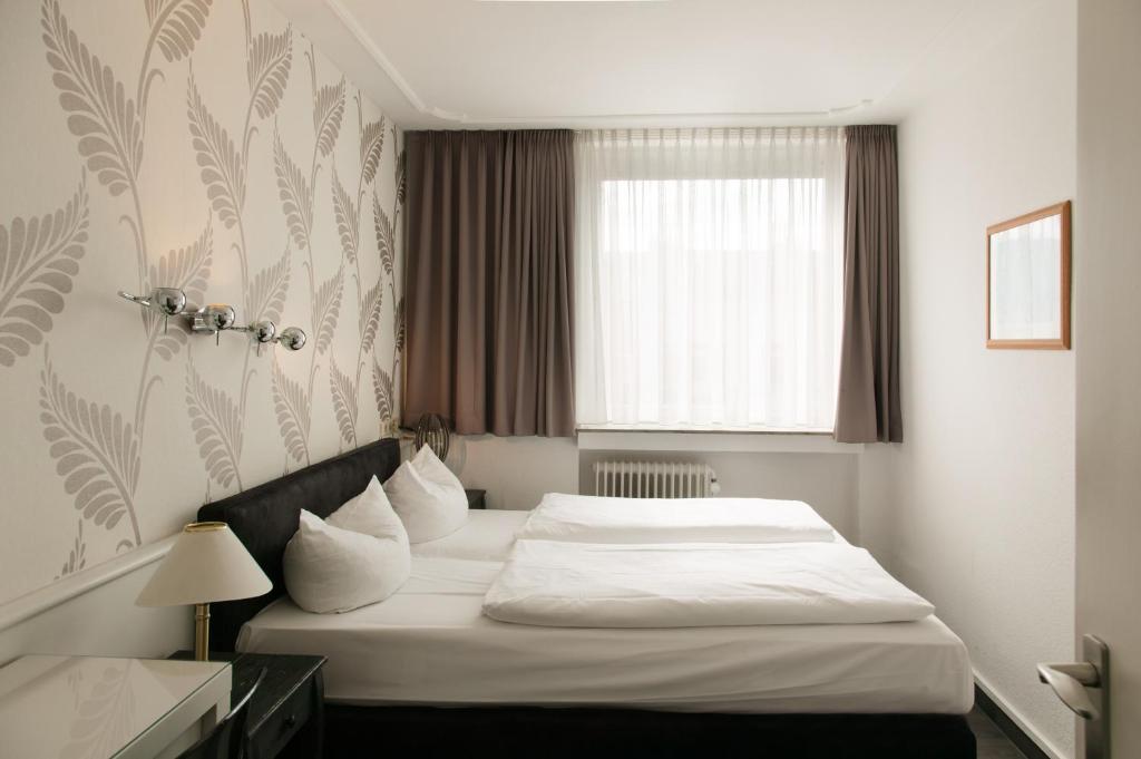 Postel nebo postele na pokoji v ubytování Hotel Krone Aachen | City-Eurogress