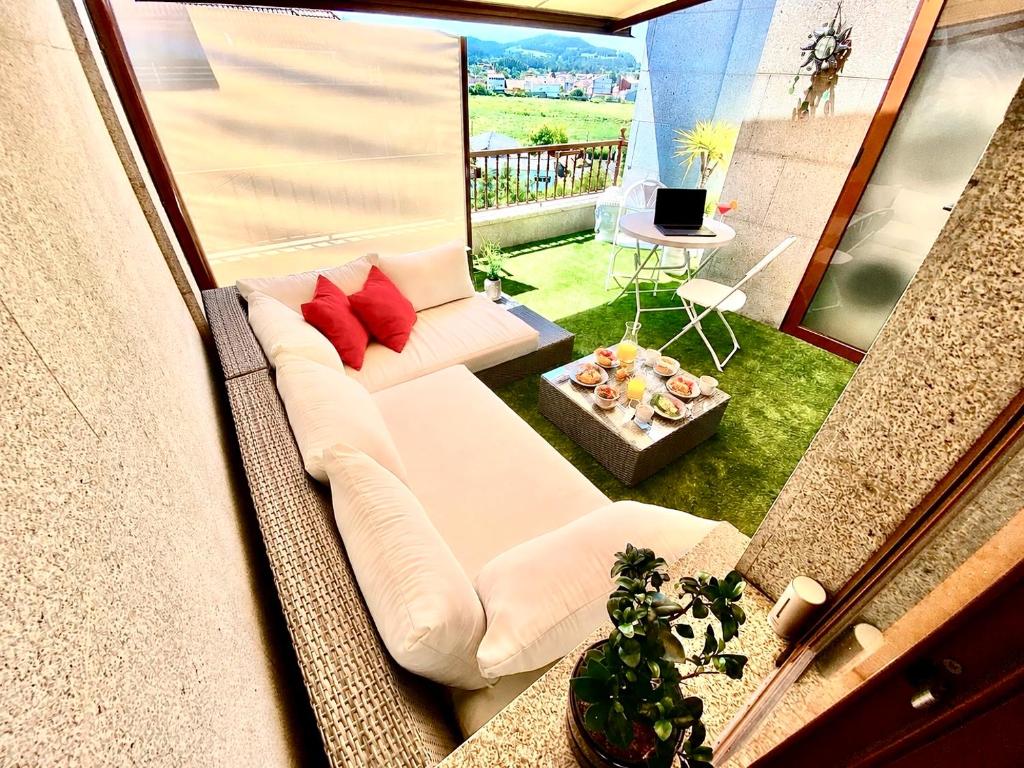 a living room with a white couch and red pillows at ÁTICO MONET - Arte y cielo frente al río del parque y junto al mar in Vilagarcia de Arousa
