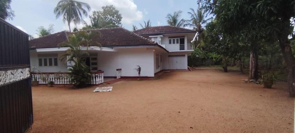 a house with a dirt yard in front of it at Deepthi Villa in Nikawatawana