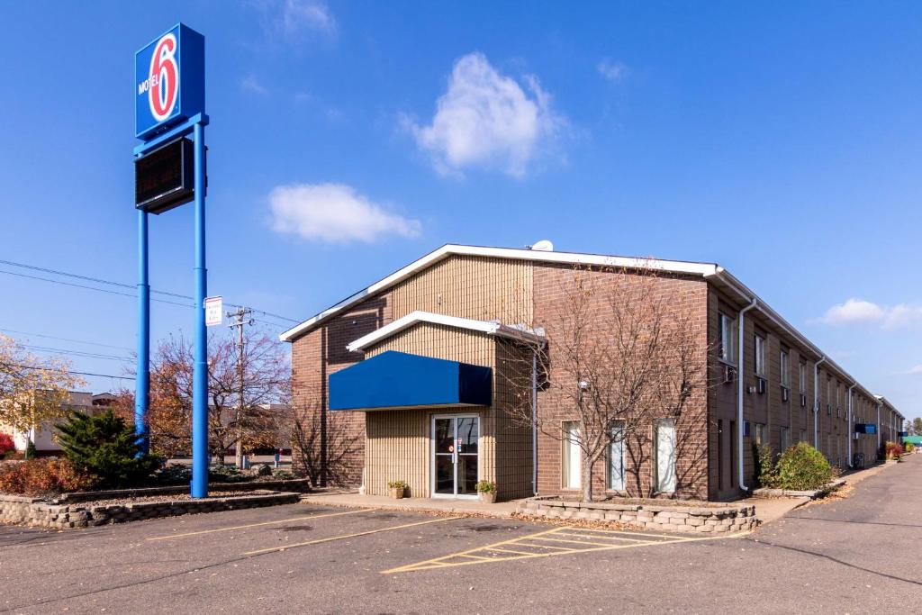 una gasolinera con un cartel delante en Motel 6-Eau Claire, WI, en Eau Claire