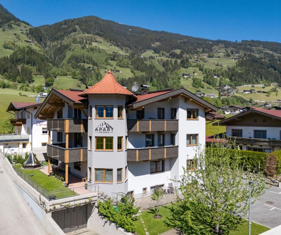 an apartment building in a village with mountains in the background at Apart Oberau - new from 2026 in Hippach