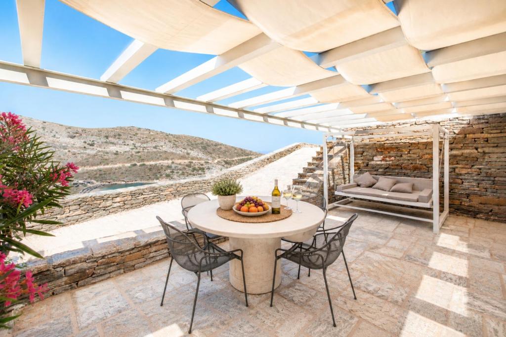 a patio with a table and chairs with a view at Marilia ViIlage Spathi Kea "Studio The Goat" in Spathi 