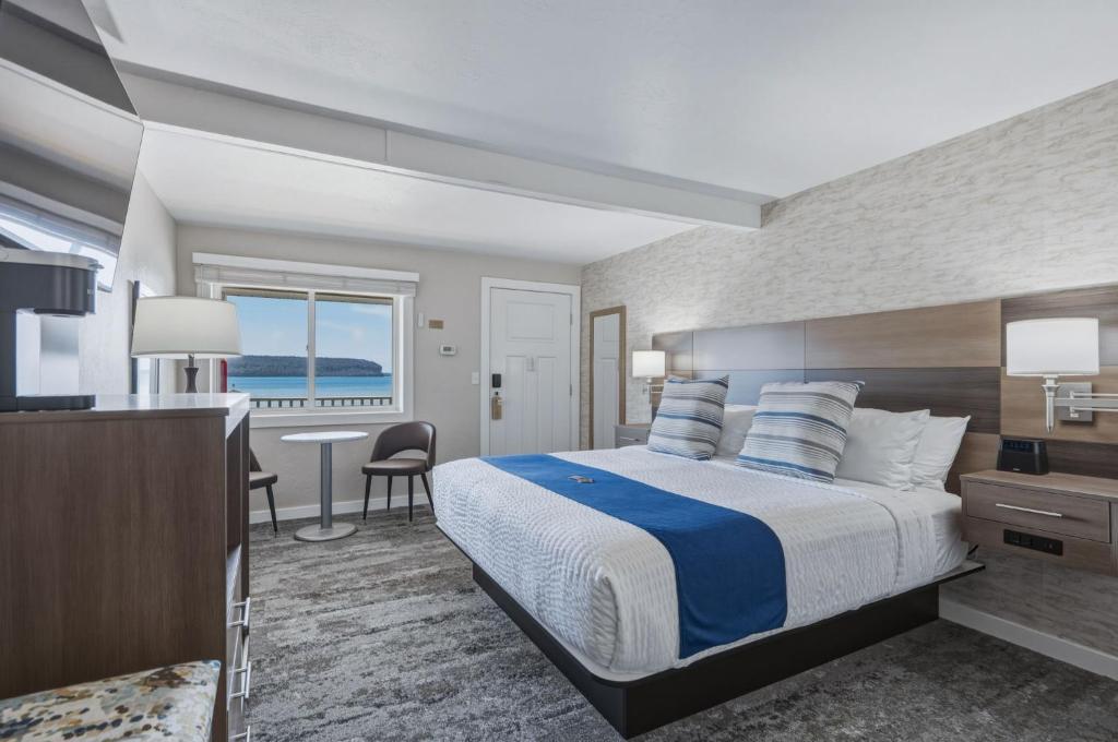 a hotel room with a bed and a view of the ocean at The Water Street Inn in Ephraim