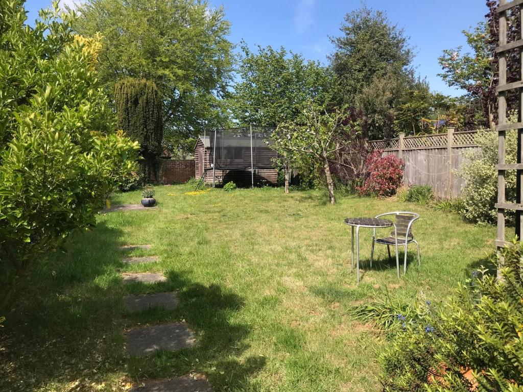 a yard with a table and chairs in the grass at Spacious Suffolk Cottage in Village Setting in Westleton