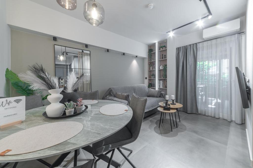 a dining room and living room with a table and chairs at Friendly Backyard in Thessaloniki