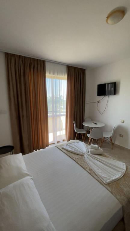 a bedroom with a large white bed and a table at Hotel Bregu I Detit Erm Spille in Spille