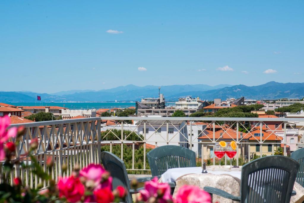 a table on a balcony with a view of a city at Hotel Sylvia in Lido di Camaiore