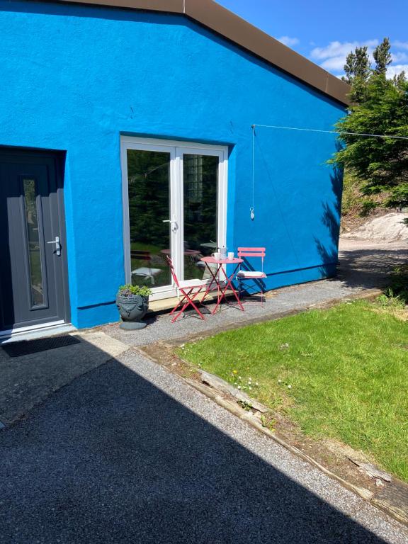 a blue house with a table and chairs in front of it at The Blue Lodge in Galway