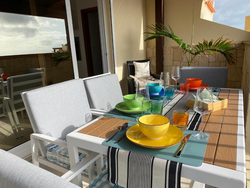 a table with a yellow bowl and plates on it at Seaview Luxury Penthouse Mare in Sal Rei