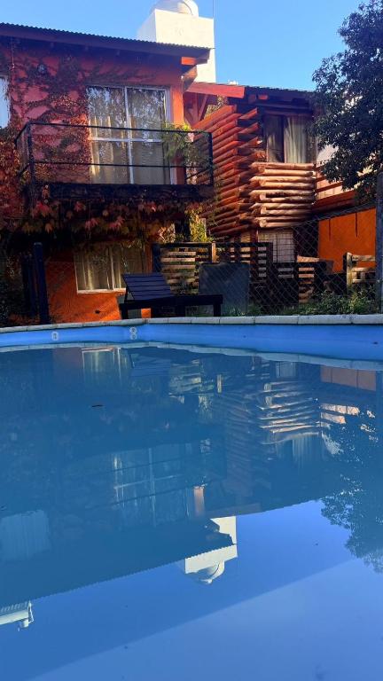 a house with a swimming pool in front of a house at Posada del Guardián in Villa Yacanto