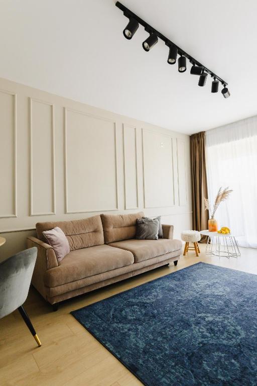a living room with a brown couch and a blue rug at Cozy Getaway Sector 1 in Bucharest