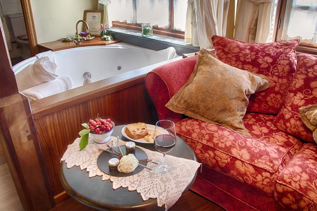 sala de estar con bañera y mesa con copas de vino en La Moncloa de San Lazaro, en Cacabelos