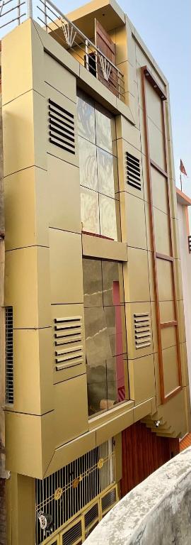 a yellow building with windows and a balcony at Govind atithi greh in Ayodhya