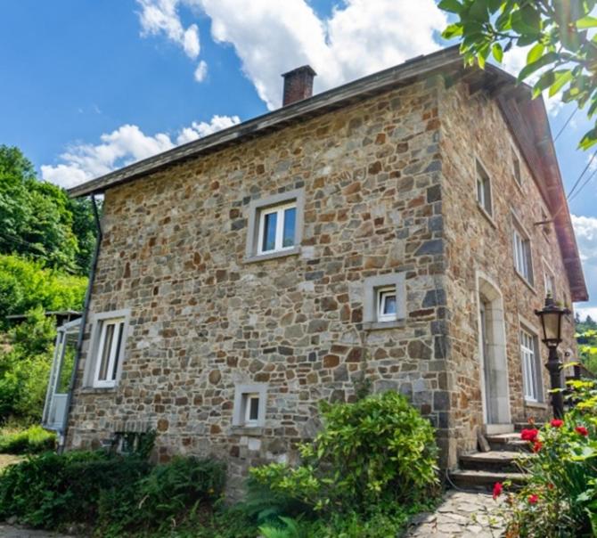 ein altes Steinhaus mit weißen Fenstern und Treppen in der Unterkunft L'Eauberge in La-Roche-en-Ardenne