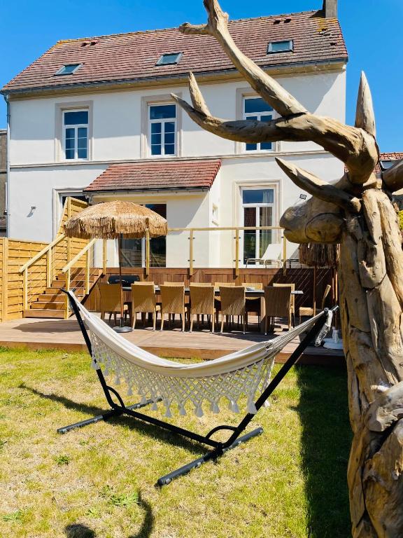 a hammock in a yard in front of a house at Villa Le Cygne in Wimereux