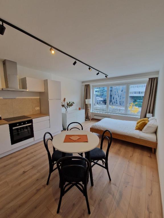 a bedroom with a bed and a table and chairs at Studio Kortrijk in Kortrijk