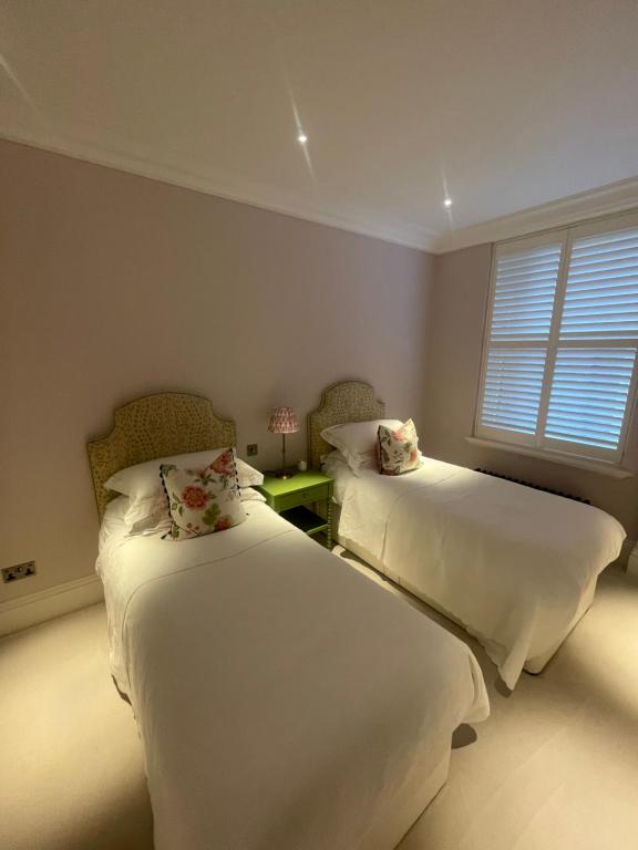 a bedroom with two beds and a window at The Brompton Residence Hotel in London