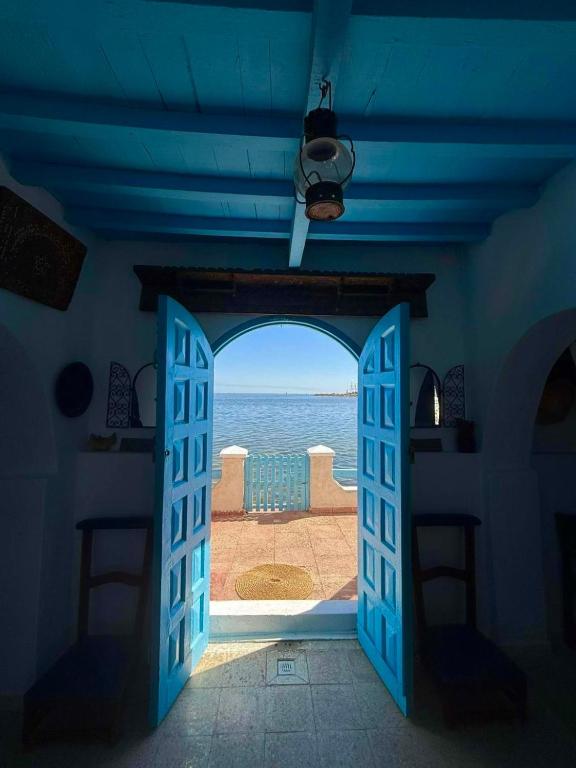 a blue door leading to a view of the ocean at El Baraka in Houmt Souk