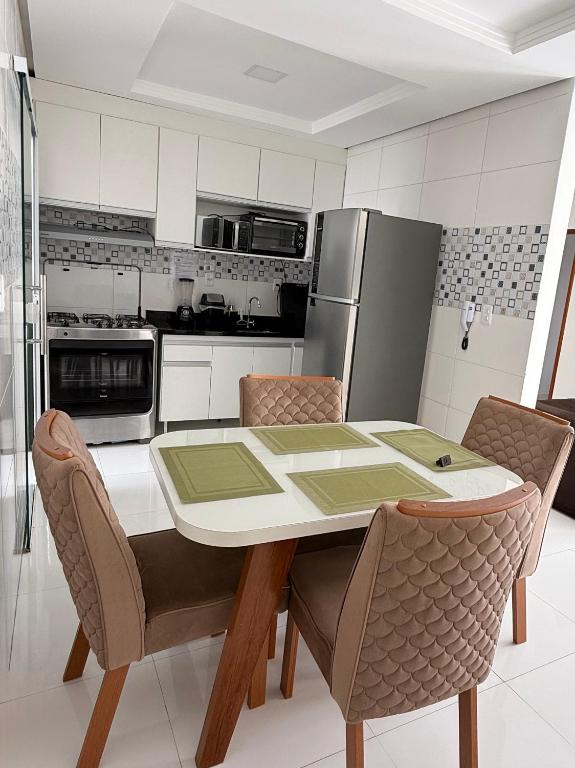 a kitchen with a table with chairs and a refrigerator at Morada dos Pássaros - Casa - 3 quartos e garagem in Vitória da Conquista