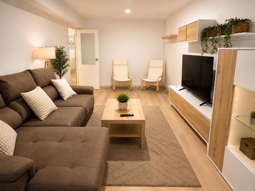a living room with a couch and a flat screen tv at Casa Vilela in Arzúa