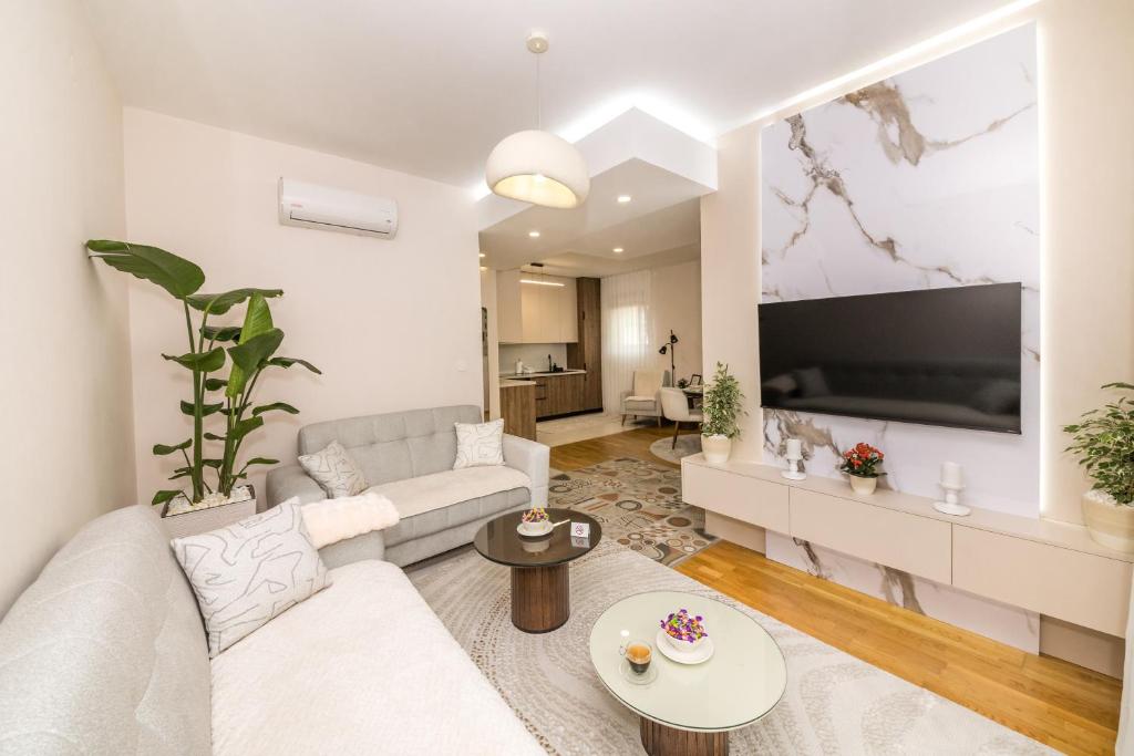 a living room with a couch and a flat screen tv at Luxury Apartment Milos in Dobrota
