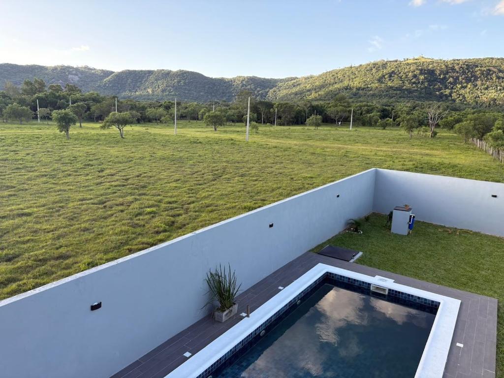 a swimming pool on the balcony of a house with a field at Escobar Sunset in Paraguarí