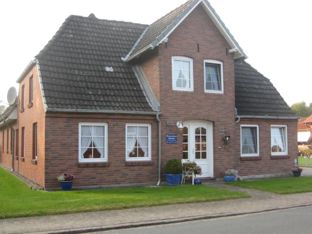 a brown brick house with a black roof at Haus Bärbel in Barlt