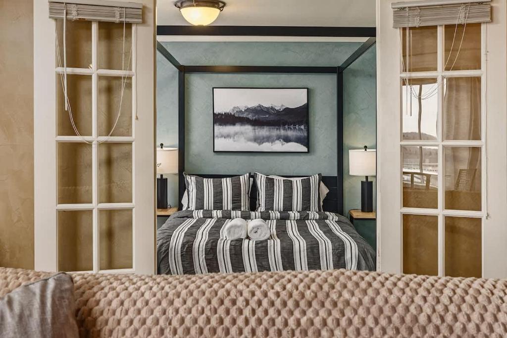 a bedroom with a bed and two windows at Downtown Condo Epic Views in Anchorage