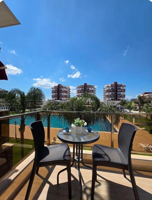 a table and chairs on a balcony with a view of a pool at Kıbrısın gözdesi Long Beach de Havuz manzaralı stüdyo daire in Trikomo