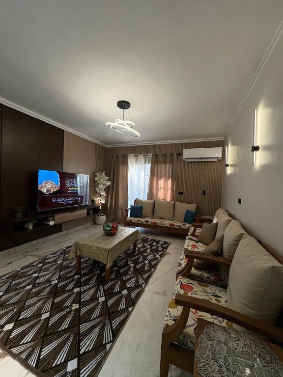 a living room with a couch and a tv at Luxury Stay in Cairo in Sheikh Zayed