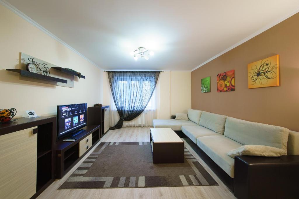 a living room with a couch and a tv at PaulMarie Apartments on Chehova in Mogilev